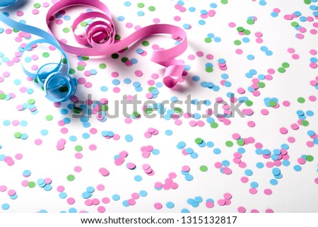 Carnival background with green, pink and blue confetti and serpentines on background