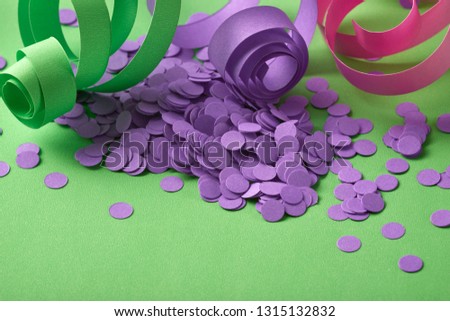 Carnival background with purple confetti and serpentines on green background horizontal