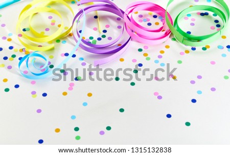 Colorful serpentines curled on white background and confetti