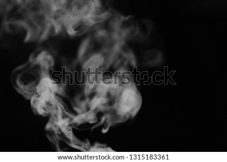 White smoke on a black background. Texture of smoke. Clubs of white smoke on a dark background for overlay

