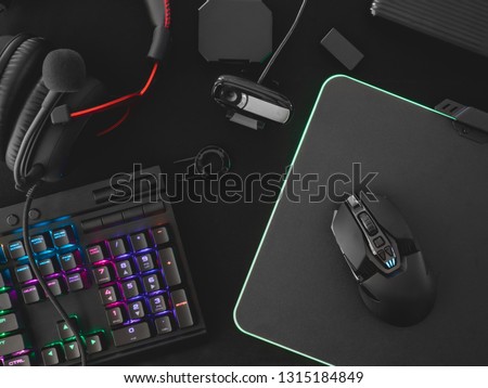 streaming games concept, top view a gaming gear, mouse, Webcams, keyboard, joystick, headset and mouse pad on black table background. Royalty-Free Stock Photo #1315184849