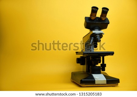 laboratory microscope, yellow background
