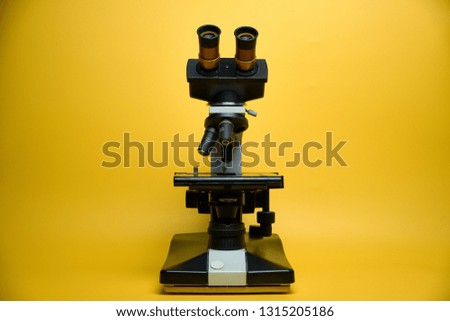 laboratory microscope, yellow background