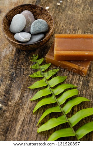 stones in bowl and fern leaf, soap on old wood