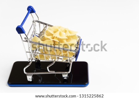 Pasta with mini cart supermarket on a smartphone, on white background. Concept of delivery, online shopping. Copy space