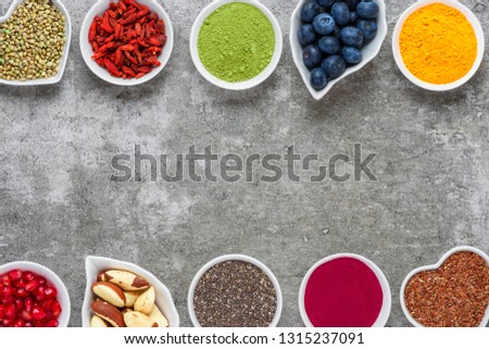 various superfoods on gray background. Superfood as chia, matcha, acai, turmeric, nuts, seeds, goji, blueberry. healthy vegan food concept. Top view with copy space Royalty-Free Stock Photo #1315237091