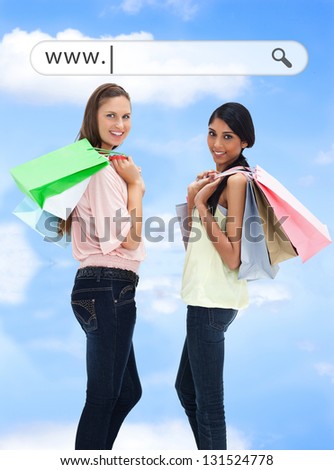 Happy girls with their shopping bags under address bar on blue sky background