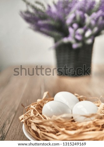Easter composition on wooden background, Easter background with Easter eggs in nest and spring flowers. Top view with copy space.