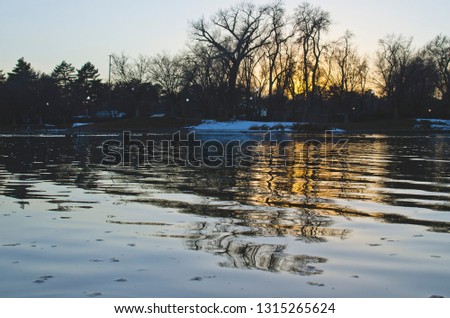 The cold waves on the pond in the city park on the cold winter lake. 