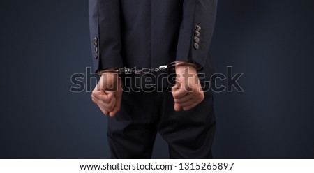 Close now arrested men hand with dark background and handcuffs