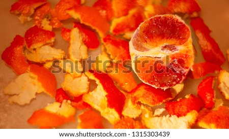Juicy delicious grapefruit or orange cut in half lies on a peel. Bright red variety tangerine for juice. Mandarin of soft focus on blurred background. Game of color and toned image doesn’t in focus.
