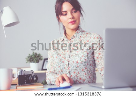 Portrait of young woman sitting at desk . young woman