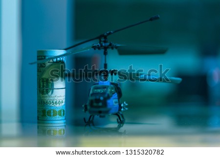 Government Military Defence Technology Abstract Background, Helicopter With Roll of US dollar Banknote, Concepts Of Modern Military Operation Cost. 