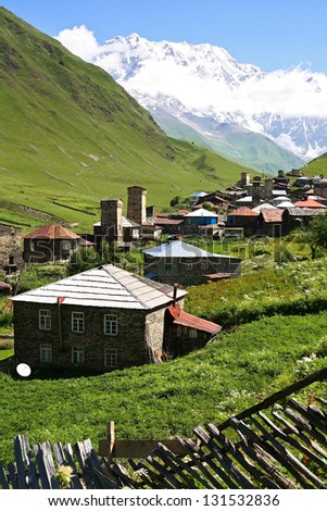 Village surrounded by snowy mountain peaks