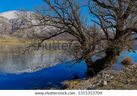 views of the lake matese in winter with the almost icy surface and snow-capped mountains. Regional area of ​​the massif of matese in the region of campania