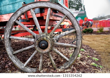 Closeup of old wagon wheel with red background