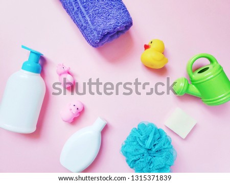 Flat lay composition photography liquid soap, purple towel, baby shampoo, blue sponge and rubber toys. Cosmetics and bath products for kids