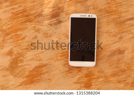 close up - a white smartphone and a black smartphone on an old wooden background
