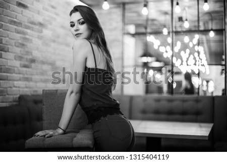 Black and white photo. Beautiful girl in the loft interior. Well-built composition of the frame