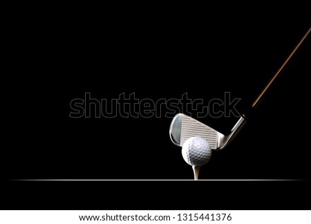 Golf ball on the tee on plain black background