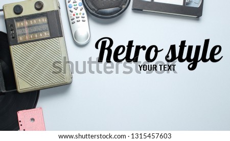 Retro style. Radio receiver, vinyl record, audio cassette, video cassette, tv remote on a gray background. Top view, copy space
