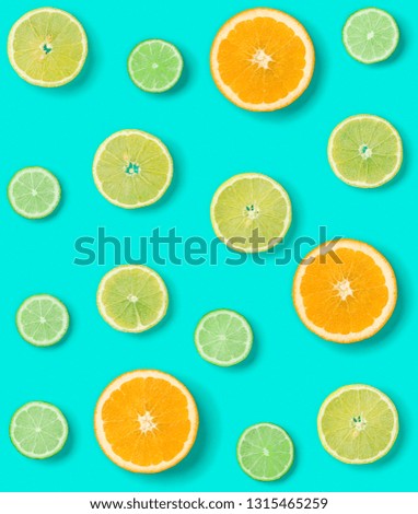 Creative layout made of colorful tropical fruits isolated on blue background. Minimal summer exotic concept. Citrus fruit seamless pattern.  Pop art, flat lay, top view. Orange, Lime, Lemon slices.