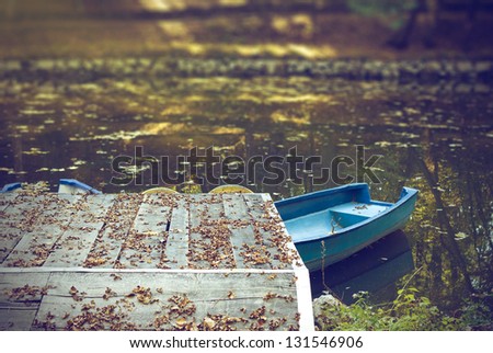 Blue boats on lake in autumn season. Peaceful scene.