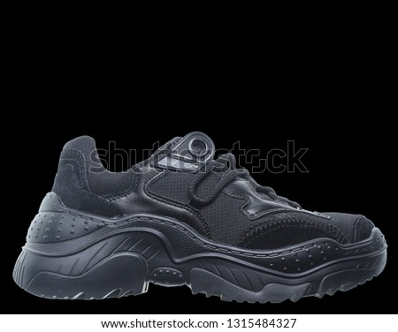 Black sneaker isolated on black background. Side view.
