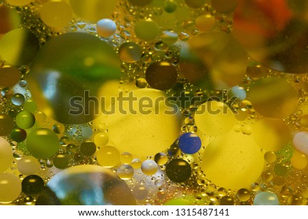 Floating in the water abstract colorful, yellow oil drops.