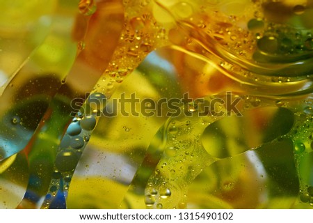 Floating in the water abstract colorful, yellow oil drops.