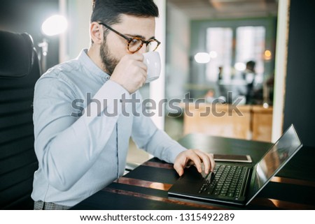  business office worker in the workplace with glasses and a beard drinking coffee in the morning. concept of career corporation.