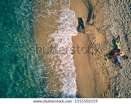 Beautiful beach with family top aerial view drone shot. Summer family vacation. Sithonia, Greece. 
