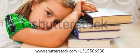 Girl doing homework. The child was tired of congestion at the school. big burden on students. overloaded child