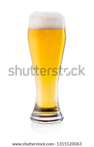 Cold light lager beer with drops and foam in glass. isolated  