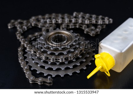 A gear and chain on a workshop table. Oiling and repair of bicycle drive. Dark background.