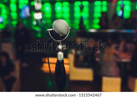 Microphone. Retro microphone. A microphone on stage. A pub. Bar. Restaurant. Classic. Evening. Night show. European restaurant. European bar. American restaurant. American bar.