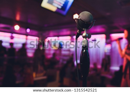 Retro microphone against blur colorful light in pub and restaurant background.