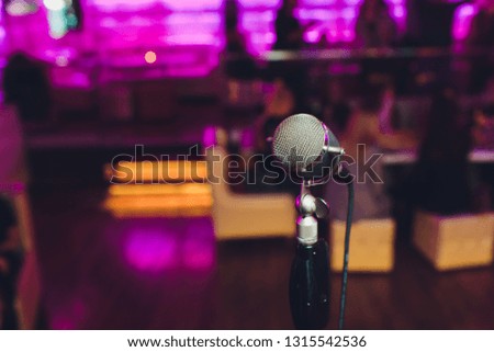 Microphone. Retro microphone. A microphone on stage. A pub. Bar. Restaurant. Classic. Evening. Night show. European restaurant. European bar. American restaurant. American bar.