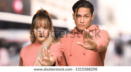 Young couple making stop gesture denying a situation that thinks wrong at city