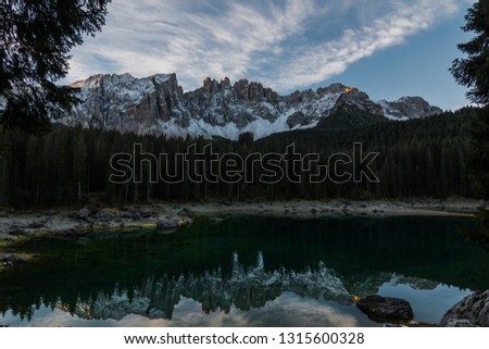 Panoramic view of Lago Di Carezza with reflections of mountains and sky on lake in South Tyrol in Northern Italian Dolomites during the fall. 