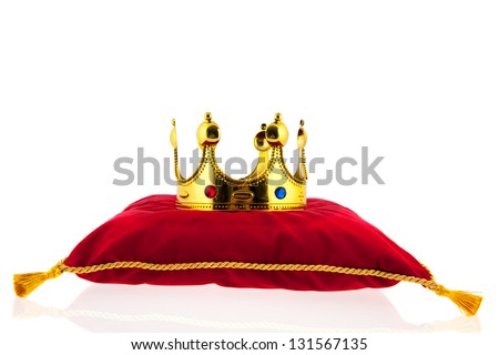 Golden crown on red velvet pillow for coronation Royalty-Free Stock Photo #131567135