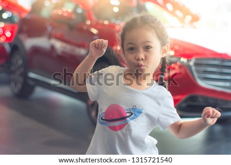 Asian kid girl looking smile posting enjoy on car blurred bokeh background for automotive automobile or transportation advertising