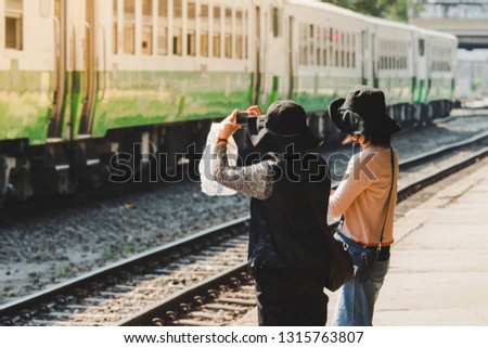 Women take photo of old trains in the train station