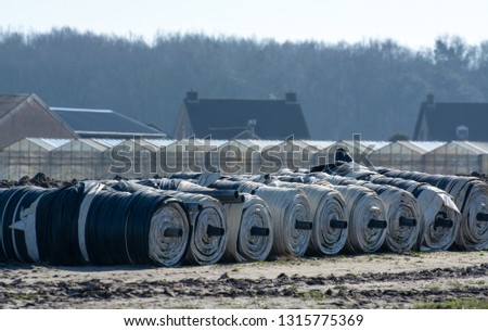 Rolls with plastic film for covering white asparagus fields, begin of new asparagus season on asparagus farm in Netherlands, counlty spring landscape