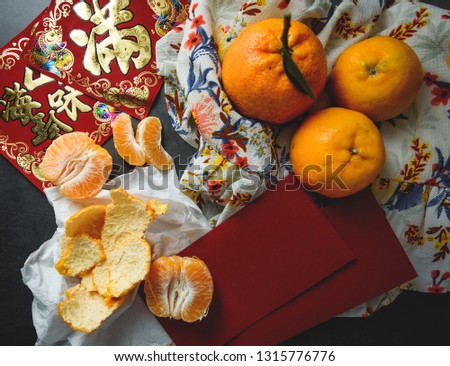 Oranges, red envelopes and greeting Chinese characters are representative items for Chinese new year. Chinese texts are telling wishes to earn lots of money and good fortune in the upcoming year.