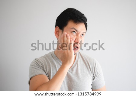 Funny face of angry Asian man punish himself by hit on his own face. Royalty-Free Stock Photo #1315784999