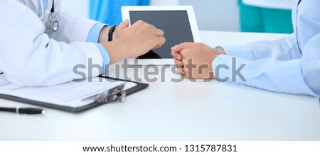 Doctor and patient discussing something, just hands at the table, white background. Physician pointing into tablet screen