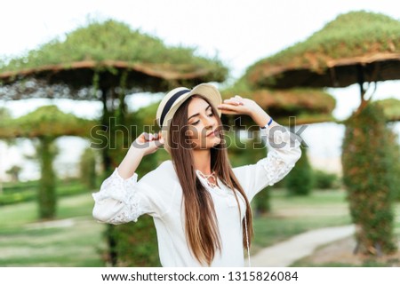 Portrait of woman in straw hat standing on the beach background