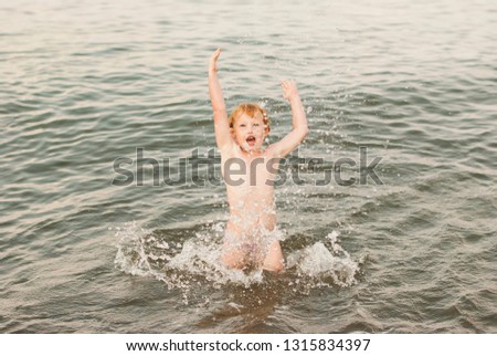 child is having fun in the water, in the sea, sea spray, happy childhood, summer joys, family holidays