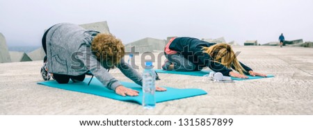 Unrecognizable young and senior woman stretching back outdoors by sea pier